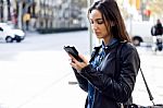 Beautiful Young Woman Using Her Mobile Phone In The Street Stock Photo