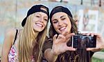 Beautiful Young Women Using Mobile Phone In The Street Stock Photo