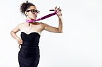 Black Woman In Evening Dress Playing With A Tie. Concept Of Domination And Authority Stock Photo