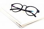 Blank Spiral Notebook And Eyeglasses Isolated On White Background Stock Photo