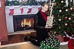Blonde Female In Holiday Scene Holding Gift Stock Photo
