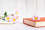 Books Or Journal With Flowers Arranged On A Neutral White Painted Desk Stock Photo