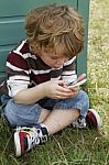 Boy Playing On Phone Stock Photo