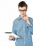 Boy Thinking By Holding Tablet Pc Stock Photo