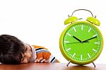 Boy Tired Of Study And Sleeping Near The Clock Stock Photo