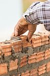 Bricklayer Working In Construction Site Of A Brick Wall Stock Photo