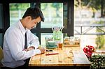 Business Man Using Mobile Phone While Sitting In The Coffee Shop Stock Photo