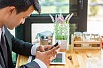 Business Man Using Mobile Phone While Sitting In The Coffee Shop Stock Photo