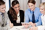 Business Team Of Four Enjoying Work Stock Photo