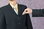 Businessman Hand Put Money To Pocket Stock Photo