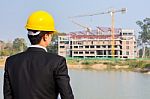 Businessman Looking At Building With Crane Stock Photo