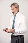 Businessman Scrolling His Contact List Stock Photo