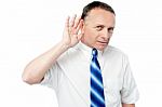 Businessman Trying To Listen Something Stock Photo