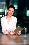 Businesswoman Browsing On Tablet Pc With A Drink Beside Stock Photo