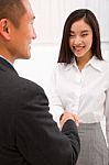 Businesswoman Shaking Hand With Businessman Stock Photo