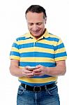 Casual Aged Man Using Mobile Phone Stock Photo