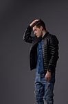 Casual Young Man In Black Leather Jacket And Denim Jeans Stock Photo