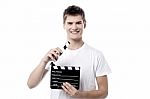 Cheerful Guy Holding Clapperboard Stock Photo