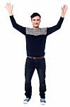 Cheerful Young Guy Raising His Arms Stock Photo
