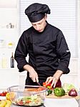 Chef Cutting Bell Peppers In Kitchen Stock Photo