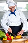 Chef Cutting Vegetables In Kitchen Stock Photo