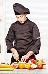 Chef In Black Uniform Cutting Fruit Stock Photo