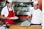 Chef Picking Pizza, Ready To Be Served Stock Photo