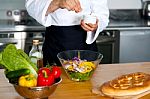 Chef Sprinkling Salt On Vegetables Stock Photo