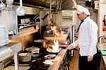 Chef With Burning Flames On Kitchen Stock Photo