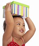 Child Holding Gift On Her Head Stock Photo
