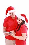 Christmas Couple Looking A Tablet Computer Stock Photo