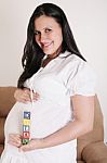 Close Up Of A Pregnant Woman With Baby Letters On Her Hand Stock Photo