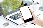 Closeup Hand Hold Smartphone And Laptop On Desk Background Stock Photo