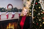 Closeup Of Blonde Female Sitting Next Christmas Tree Stock Photo