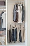 Clothes Hanging In White Wardrobe Stock Photo