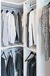 Clothes Hanging On Rail In White Wardrobe Stock Photo