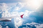 Cloudy Sky And Red Airplane Wing As Seen Through Window On Aircr Stock Photo