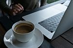 Coffee And Blur Laptop On Table Wood Background In Cafe Stock Photo