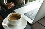 Coffee And Blur Laptop On Table Wood Background In Cafe Stock Photo