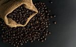Coffee Beans In Sack On Black Background Stock Photo