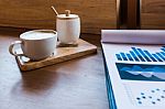Coffee Cup  On A Table With Laptob And Graph Finance Diagram In Stock Photo