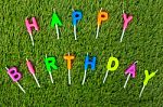 Colorful Happy Birthday Candles On Field Stock Photo