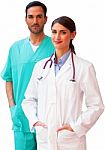 Confident Female Doctor Standing With Male Surgeon Stock Photo