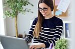 Confident Young Woman Working In Her Office With Laptop Stock Photo