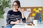 Confident Young Woman Working In Her Office With Mobile Phone Stock Photo