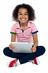 Cool Girl Kid Sitting On The Floor Holding Tablet Pc Stock Photo