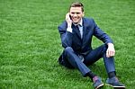 Corporate Male Relaxing On Grass Meadow Stock Photo