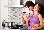Couple Drinking Wine In Their Kitchen Stock Photo