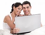 Couple Sitting In Bed With Laptop Stock Photo