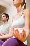 Couple Sitting On Floor Doing Yoga Stock Photo